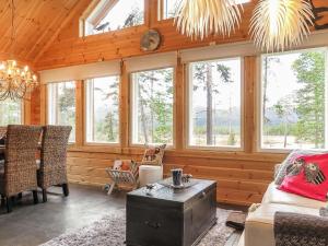 a living room with wooden walls and windows at Holiday Home Homma by Interhome in Kyrö