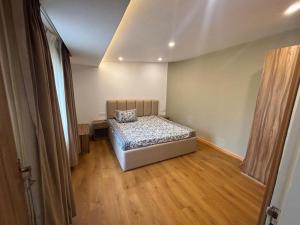 a bedroom with a bed in a room with wooden floors at Engineers Retreat in Srinagar