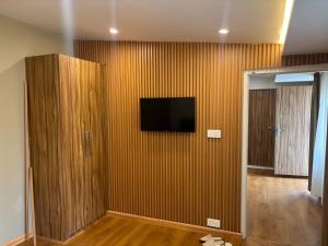 a living room with a television on a wall at Engineers Retreat in Srinagar