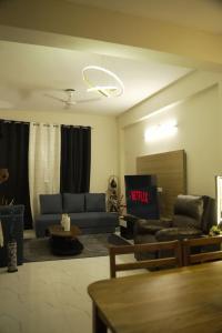 a living room with a couch and a tv at Nirvaan Nest in Faridabad