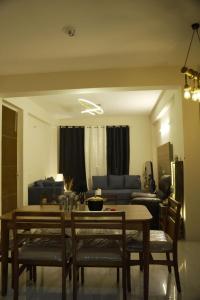 a living room with a table and chairs and a couch at Nirvaan Nest in Faridabad