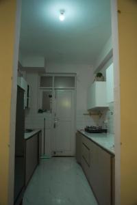 a kitchen with white cabinets and a white door at Nirvaan Nest in Faridabad