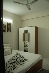 a bedroom with a bed and a large mirror at Nirvaan Nest in Faridabad