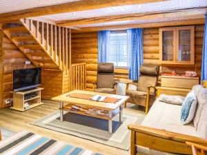 a living room with a couch and a table at Holiday Home Hanhela by Interhome in Äkäslompolo