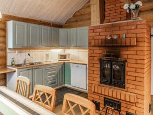 a kitchen with blue cabinets and a brick wall at Holiday Home Hanhela by Interhome in Äkäslompolo
