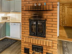 a kitchen with a brick wall with a stove at Holiday Home Hanhela by Interhome in Äkäslompolo