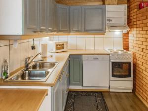 a small kitchen with a sink and a microwave at Holiday Home Hanhela by Interhome in Äkäslompolo +16 photos