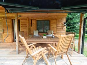 a wooden deck with a table and chairs in front of a cabin at Geofond Chaty in Chotěboř