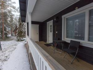 a porch of a house with two chairs and a window at Holiday Home Pihkala 2 by Interhome in Äkäslompolo