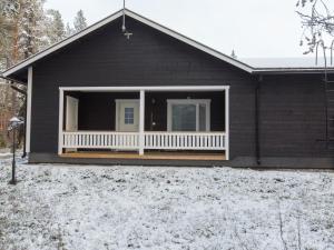 a black house with a porch in the snow at Holiday Home Pihkala 2 by Interhome in Äkäslompolo