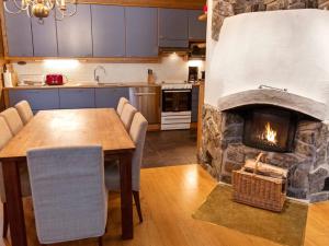 a kitchen and dining room with a stone fireplace at Holiday Home Kivalonmaa a by Interhome in Äkäslompolo