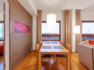 a dining room with a table and a couch at Holiday Home Ski chalets 6405 by Interhome in Ylläsjärvi