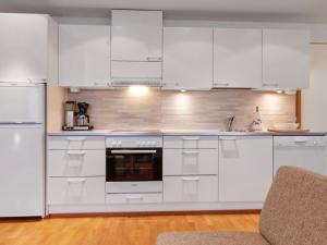 a white kitchen with white cabinets and appliances at Holiday Home Ski chalets 6405 by Interhome in Ylläsjärvi +10 photos