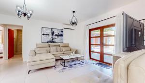 a living room with a couch and a tv at Luce del sole in Oranjestad