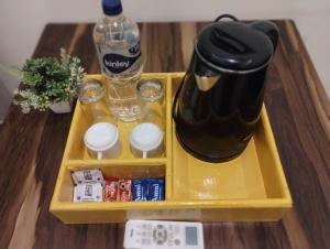 a tray with a coffee maker and a bottle of water at Sunrise Homestay Agra Near Taj Mahal in Agra