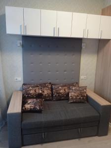 a bed with a headboard and pillows on it at Квартира-студія in Odesa
