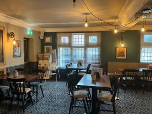 a dining room with tables and chairs and windows at Sheridans hotel in Wallasey