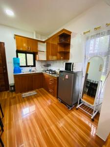 a kitchen with wooden floors and a stainless steel refrigerator at Lucas Transient House in Looc +17 photos