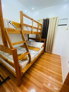 two bunk beds in a room with a wooden floor at Lucas Transient House in Looc