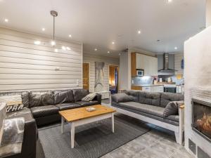a living room with a couch and a fireplace at Holiday Home Tuulenpuuska by Interhome in Äkäslompolo +19 photos