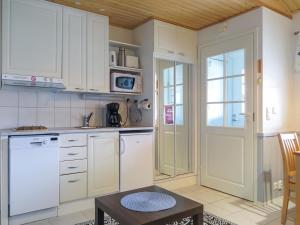 a kitchen with white cabinets and a table and a door at Holiday Home Levi star 1009 by Interhome in Levi