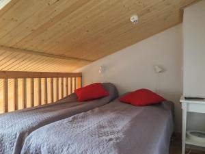a bedroom with a bed with red pillows on it at Holiday Home Levi star 1009 by Interhome in Levi