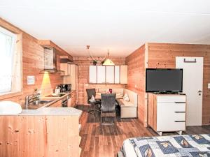 a kitchen with wooden walls and a tv in a room at Apartment Barbara-2 by Interhome in Fügen +24 photos
