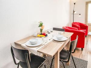 a dining room with a wooden table and red chairs at Studio Diure 0113 by Interhome in Verbier