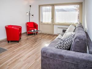 a living room with a couch and two red chairs at Studio Diure 0113 by Interhome in Verbier