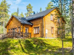 a wooden house on a hill with trees at Holiday Home Tervakko by Interhome in Luosto