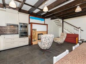 a living room with two chairs and a kitchen at Holiday Home Halmesaari by Interhome in Kerkonjoensuu +12 photos