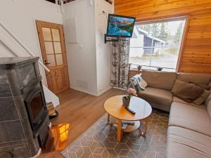 a living room with a couch and a tv at Holiday Home Kätkäläinen e 2 by Interhome in Levi +9 photos