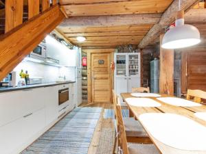 a kitchen with wooden ceilings and a long table at Holiday Home Tunturitorppa by Interhome in Äkäslompolo