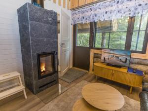 a living room with a fireplace and a table at Holiday Home Kantapää d2 by Interhome in Luosto