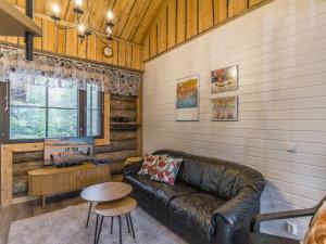 a living room with a leather couch and a table at Holiday Home Kantapää d2 by Interhome in Luosto