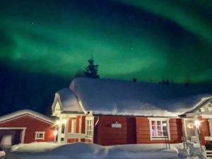 a house with the aurora in the sky at Holiday Home Vuonkuma by Interhome in Äkäslompolo