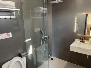 a bathroom with a shower and a toilet and a sink at Lạng Sơn Marina Hotel in Lạng Sơn