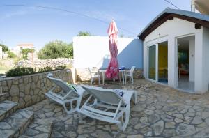 a patio with chairs and a table and an umbrella at VIScovery apartments in Vis