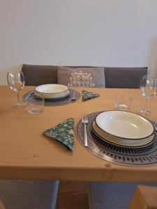a wooden table with plates and wine glasses on it at Suite Panorama in Valdisotto
