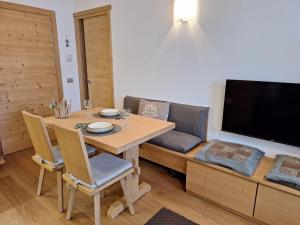 a dining room with a table and a couch at Suite Panorama in Valdisotto +15 photos