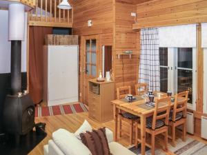 a living room with a table and a stove at Holiday Home Yllästokka 7 by Interhome in Ylläsjärvi