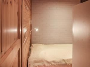 a small bedroom with a bed and a brick wall at Holiday Home Yllästokka 7 by Interhome in Ylläsjärvi