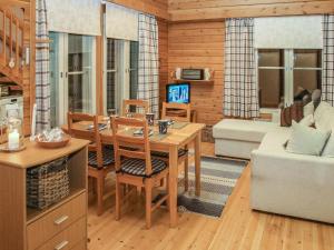 a kitchen and living room with a table and a couch at Holiday Home Yllästokka 7 by Interhome in Ylläsjärvi