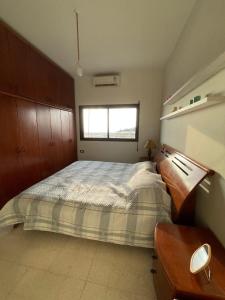 a bedroom with a bed and a desk and a window at antelias mainroad apartment in An Naqqāsh