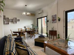 a living room with a couch and a table at antelias mainroad apartment in An Naqqāsh