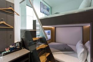Habitación pequeña con litera y escritorio. en The Z Hotel City, en Londres