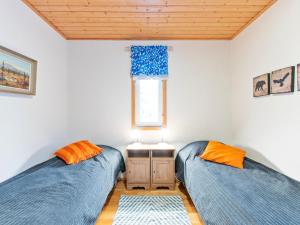 two beds in a room with a window at Holiday Home Aamutähti by Interhome in Äkäslompolo