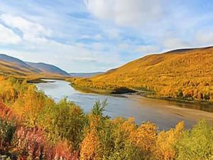 a river in the middle of a valley with trees at Holiday Home Karetörmä by Interhome in Nuorgam