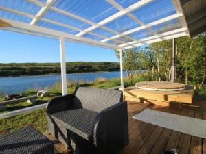 a patio with chairs and a table and a lake at Holiday Home Karetörmä by Interhome in Nuorgam +28 photos