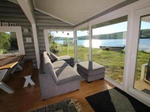 a living room with two chairs and a table and windows at Holiday Home Karetörmä by Interhome in Nuorgam